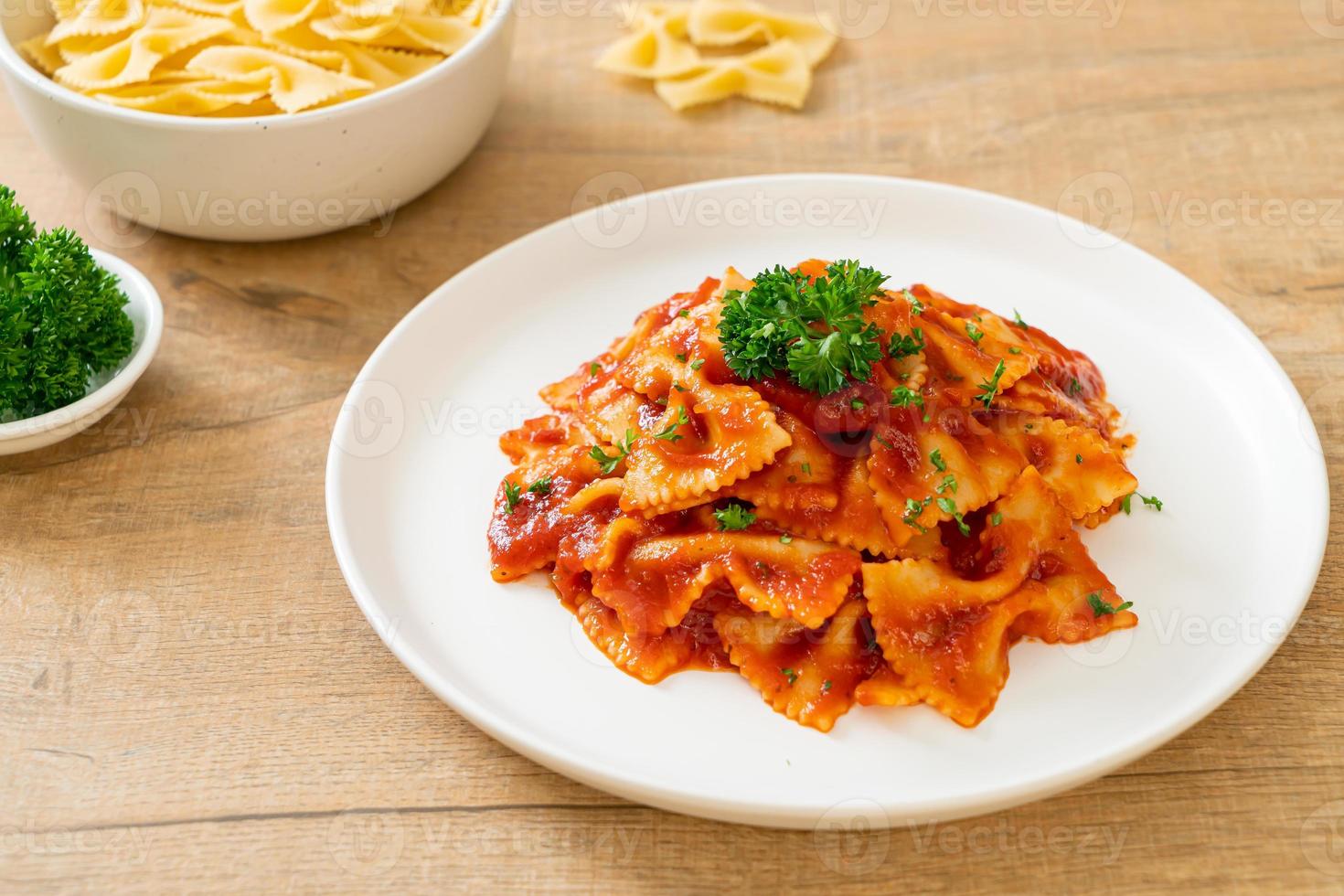 Farfalle-Nudeln in Tomatensauce mit Petersilie - italienische Küche foto