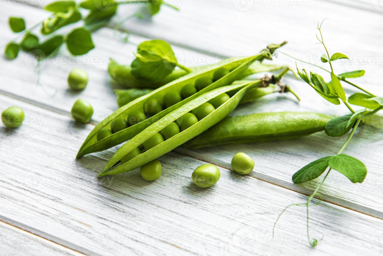 grüne Erbsen auf weißem Hintergrund aus Holz. gesunde Ernährung Hintergrund. foto