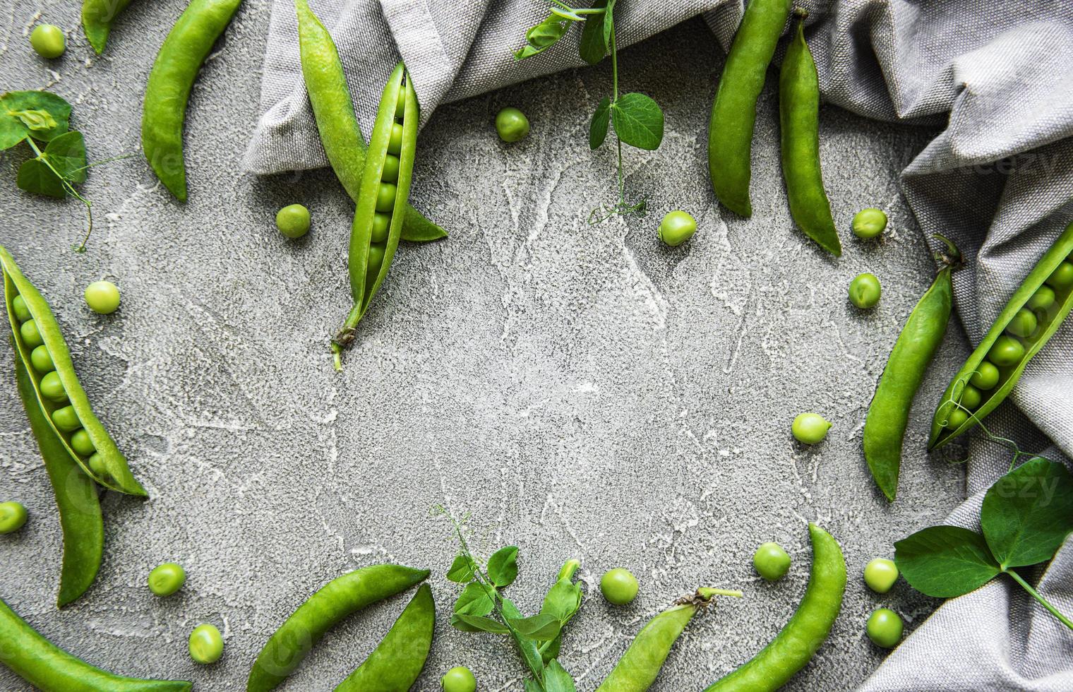 Schoten von grünen Erbsen auf einem konkreten Hintergrund. Bio-Lebensmittel. foto