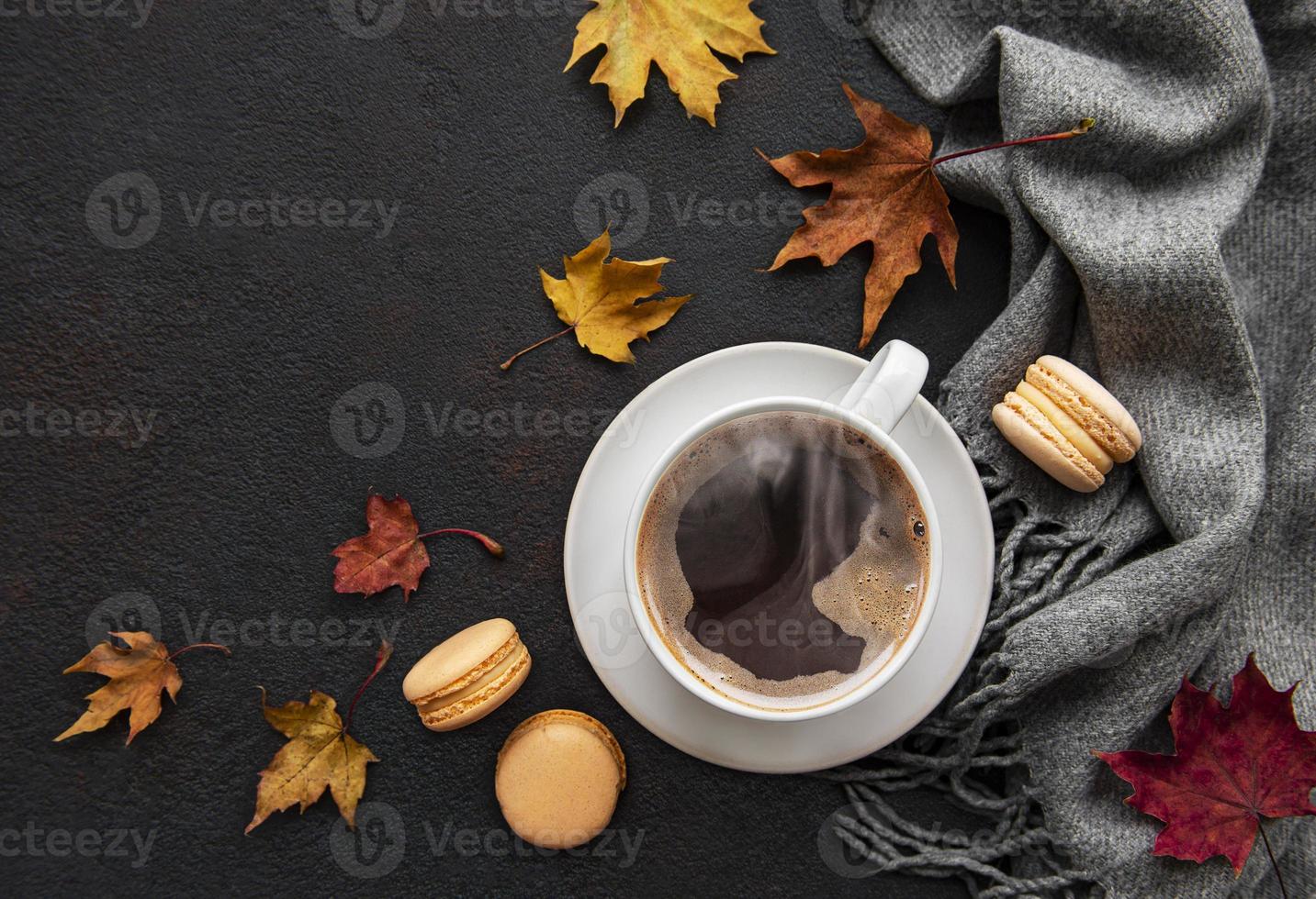 Tasse Kaffee und trockene Blätter auf schwarzem Betonhintergrund foto