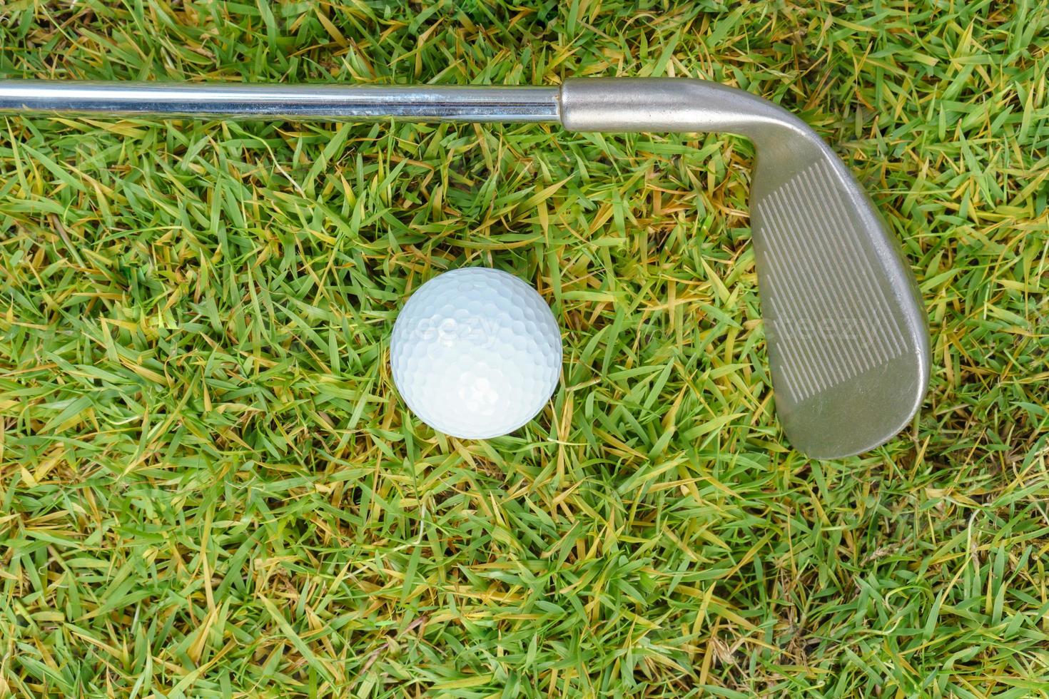 Golfschläger und Golfball auf grünem Grashintergrund foto