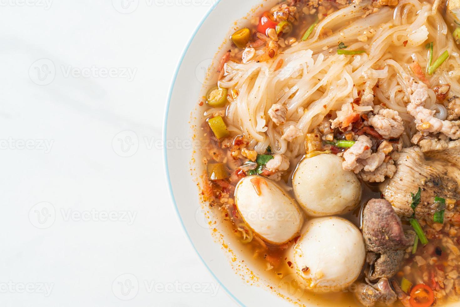 Nudeln mit Schweinefleisch und Frikadellen in scharfer Suppe oder Tom Yum Nudeln nach asiatischer Art foto