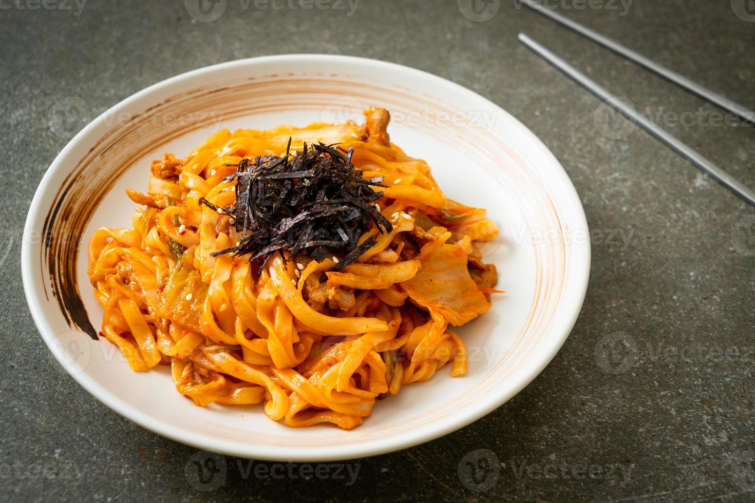 gebratene Udon-Nudeln mit Kimchi und Schweinefleisch - koreanische Küche foto