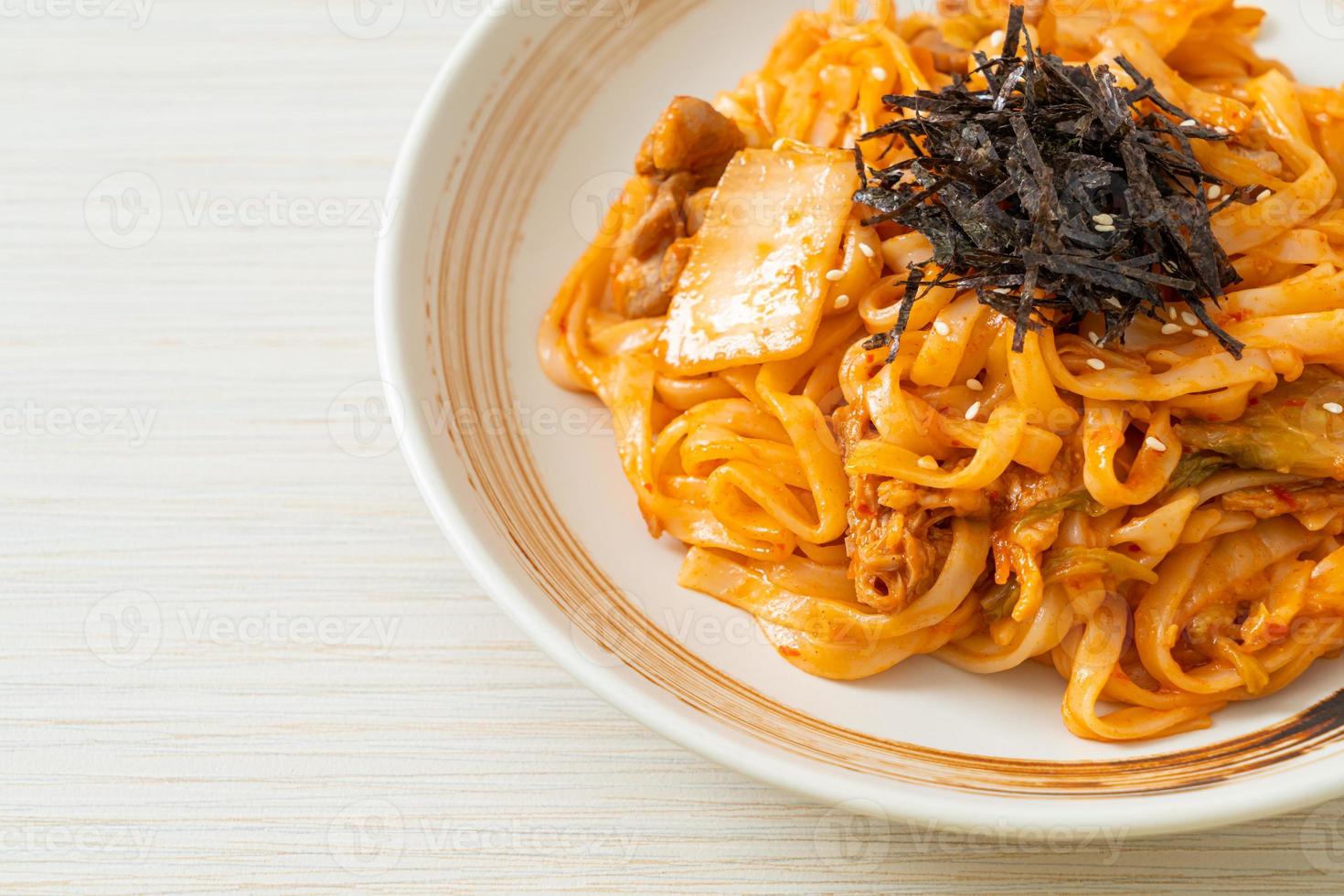 gebratene Udon-Nudeln mit Kimchi und Schweinefleisch - koreanische Küche foto