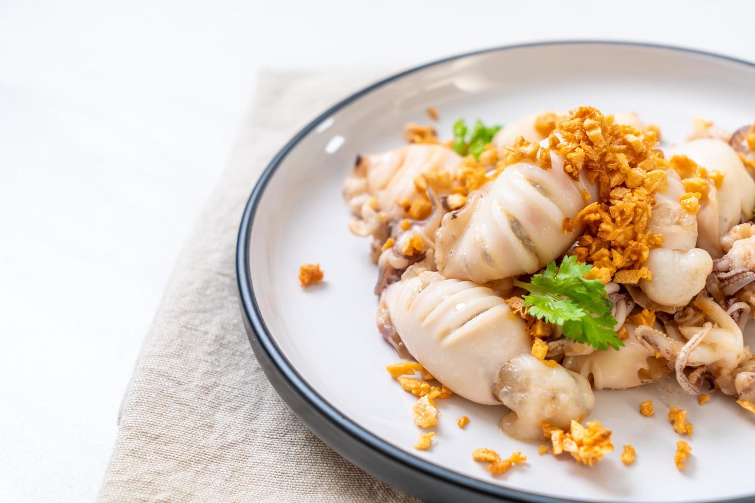 gebratener Tintenfisch oder Oktopus mit Knoblauch auf Teller foto