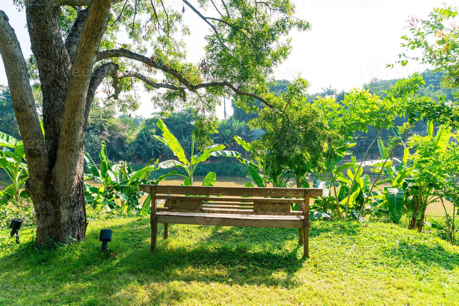 leere Holzbank im Garten mit Flussblick foto