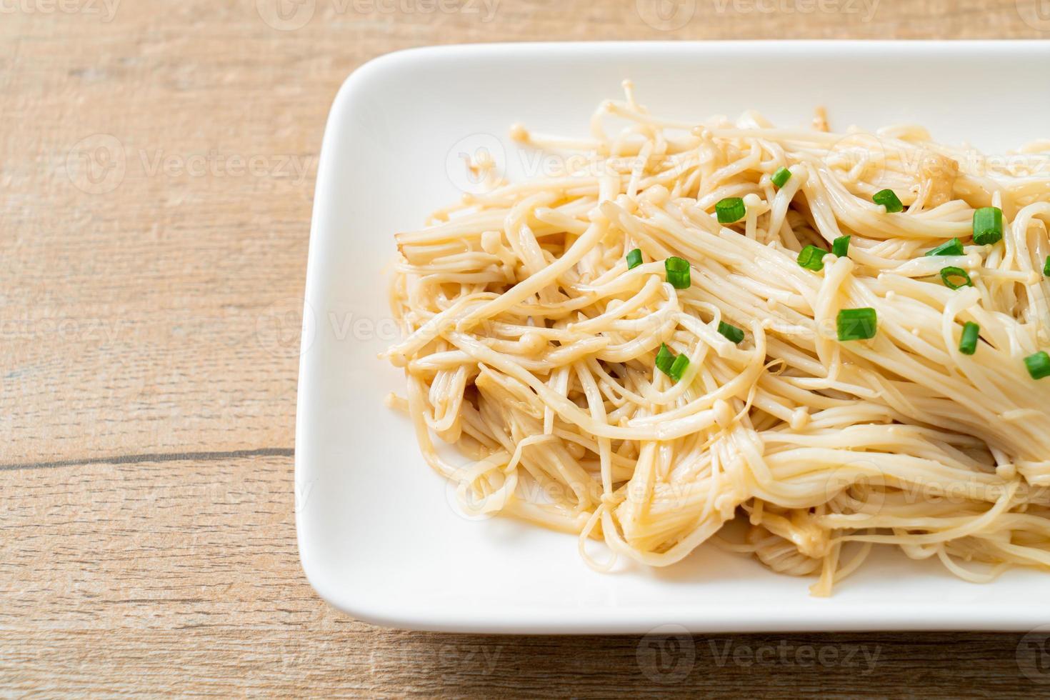 gebratener goldener Nadelpilz mit Butter auf weißem Teller foto