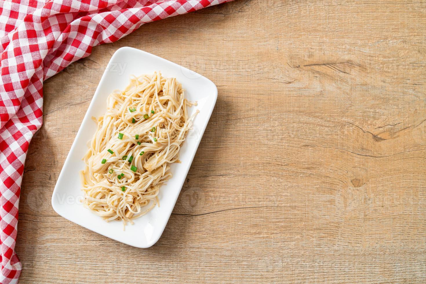 gebratener goldener Nadelpilz mit Butter auf weißem Teller foto