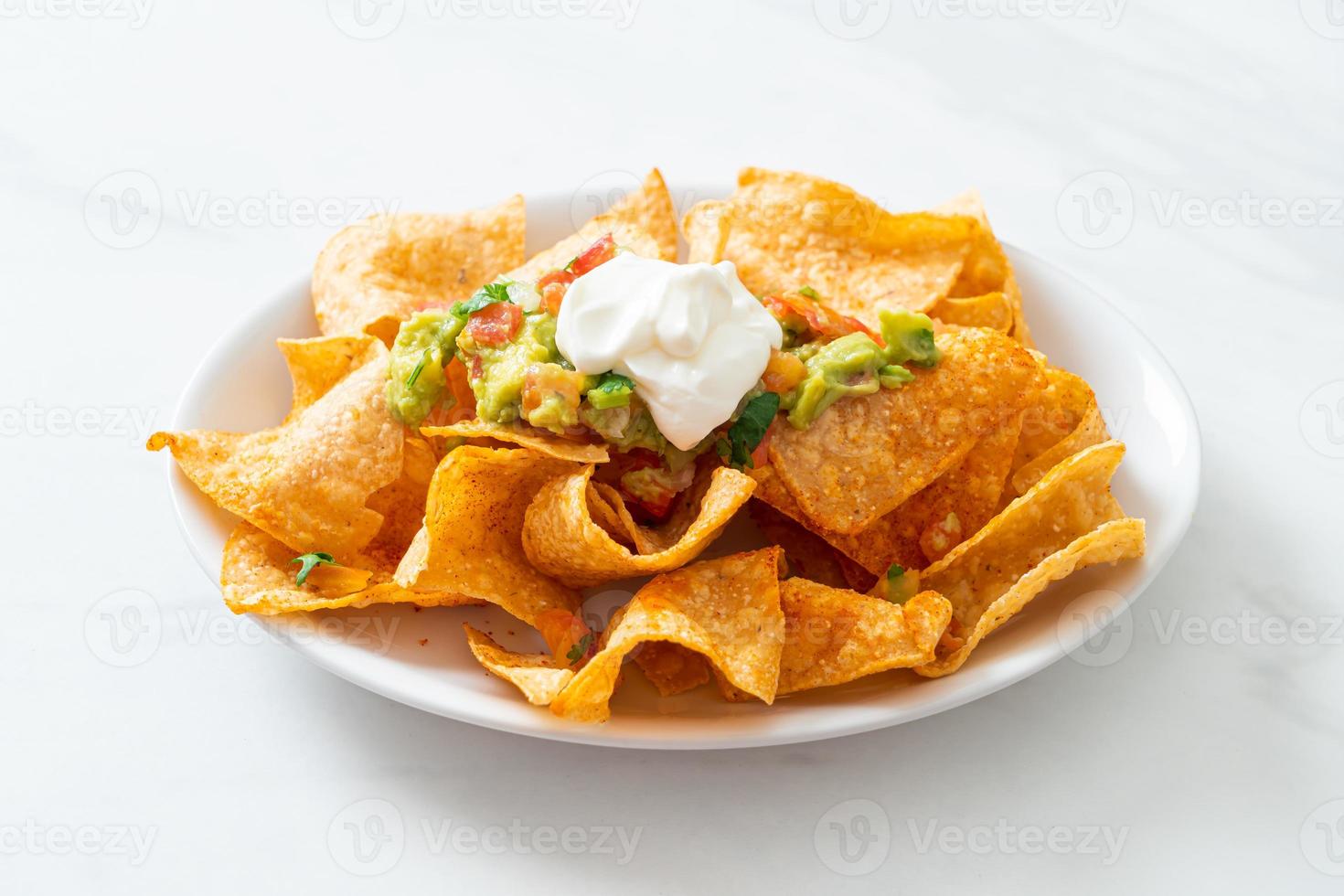 mexikanische Nachos-Tortilla-Chips mit Jalapeno, Guacamole, Tomatensalsa und Dip foto