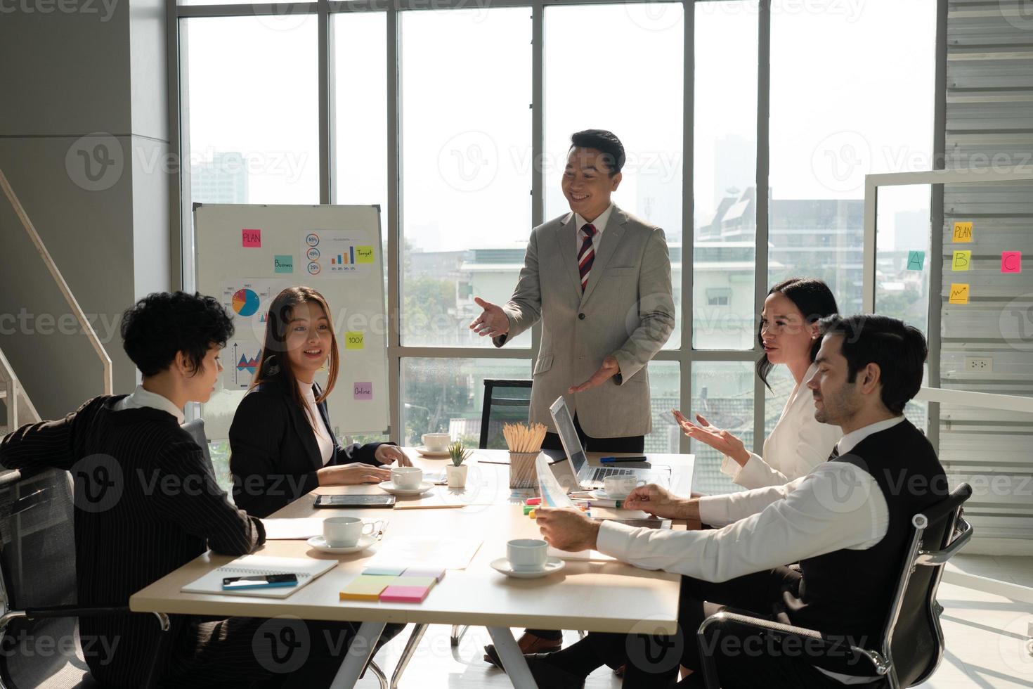 Asiatischer Manager bespricht Projekt mit multiethnischem Team in Besprechung foto