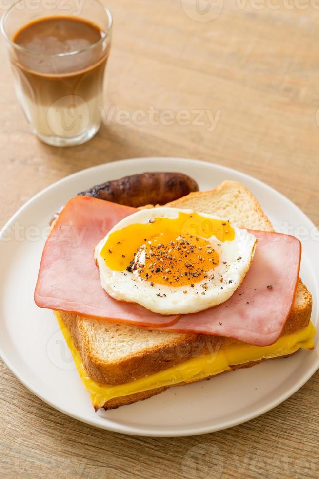 hausgemachtes Brot gerösteter Käse überbackener Schinken und Spiegelei mit Schweinswurst und Kaffee zum Frühstück foto