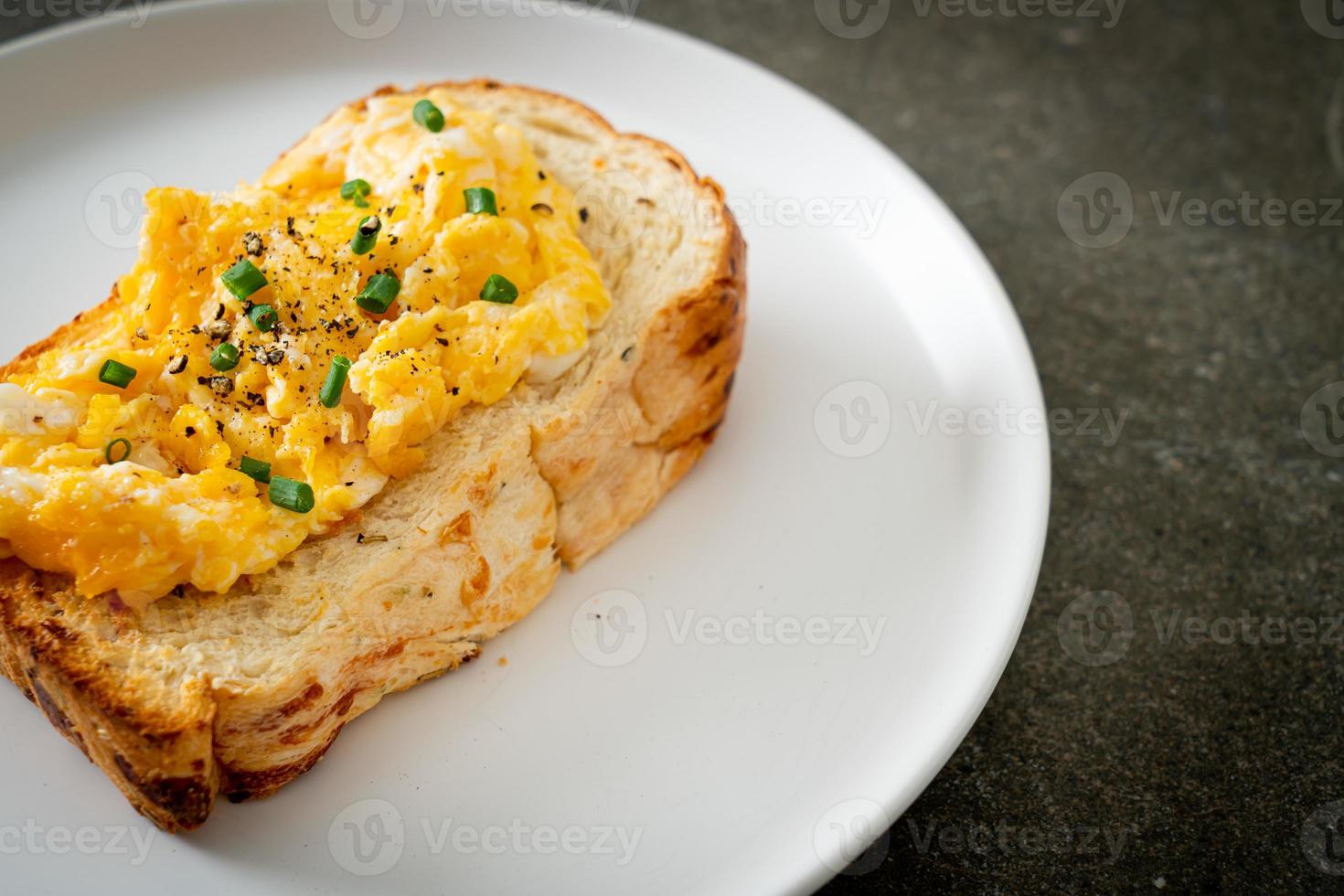 Brottoast mit Rührei auf weißem Teller foto