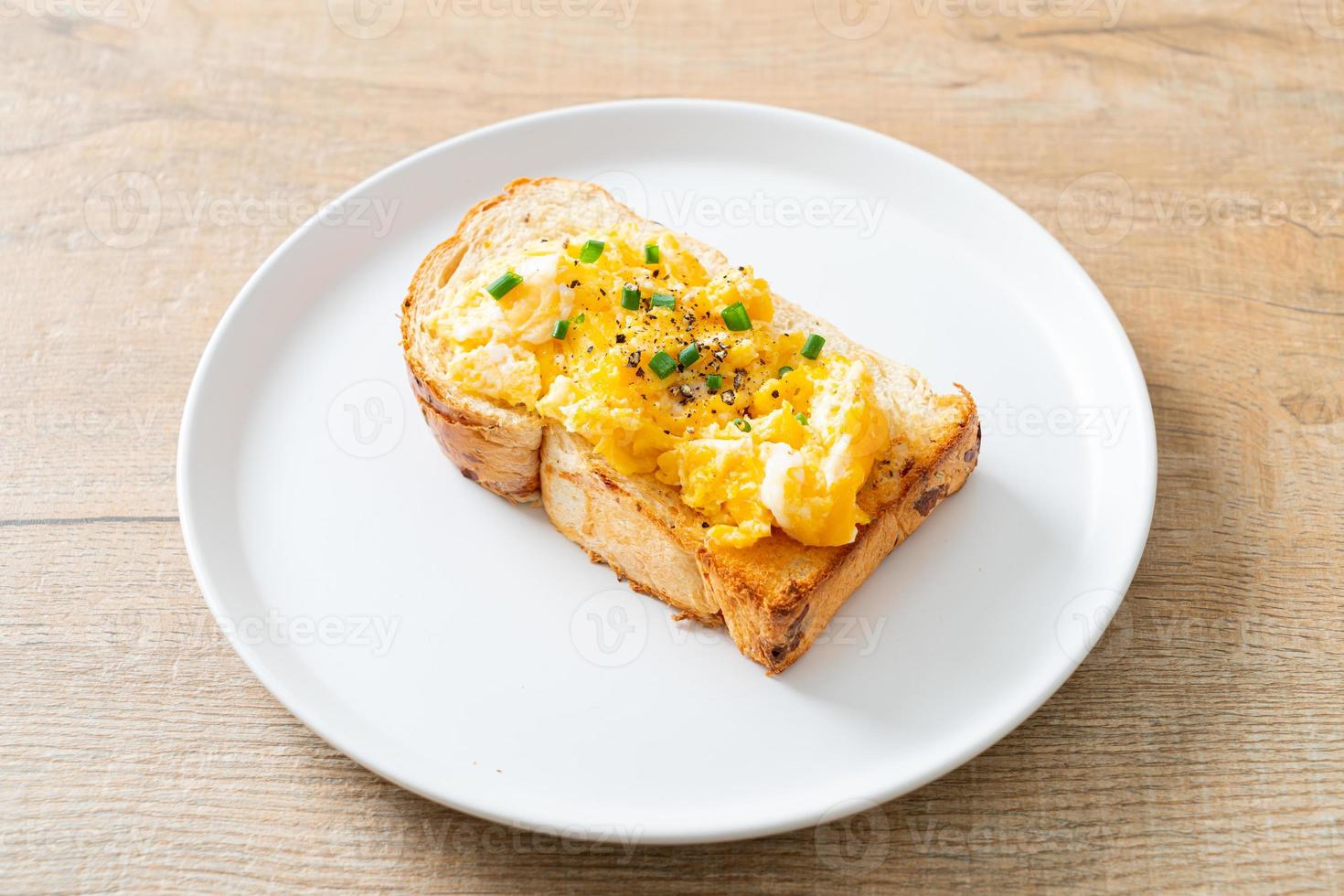 Brottoast mit Rührei auf weißem Teller foto