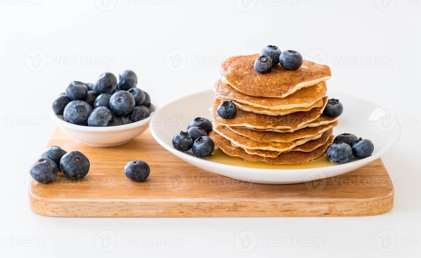 Stapel Pfannkuchen mit frischen Blaubeeren auf weißem Hintergrund foto