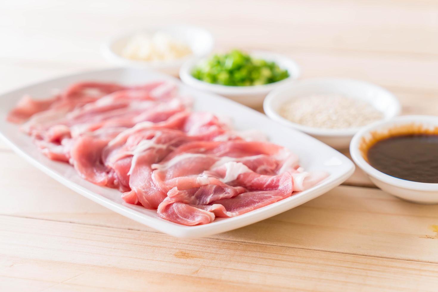 frisches Schweinefleisch in Scheiben geschnitten mit Zutaten foto