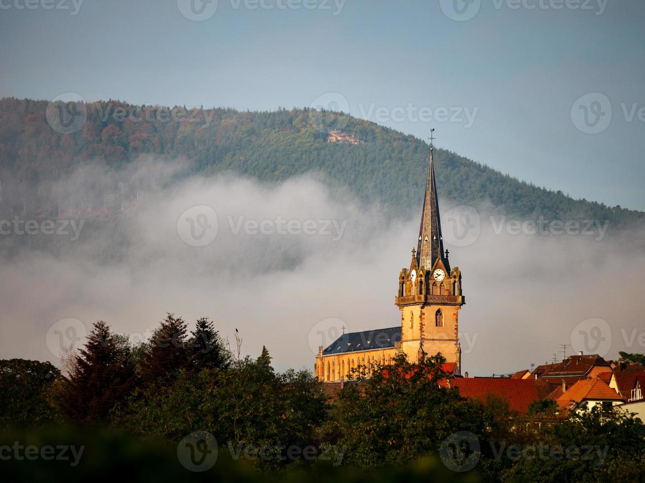 Glockenturm einer alten Kirche im Dorf Bernardschwiller im Elsass, Frankreich foto