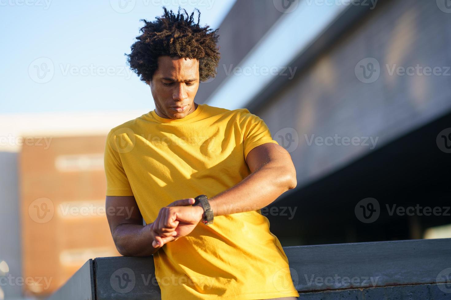 schwarzer Mann, der seine Smartwatch konsultiert, um seine Trainingsdaten anzuzeigen. foto