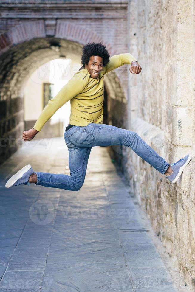 schwarzer Mann mit Afrohaaren springt vor Freude foto