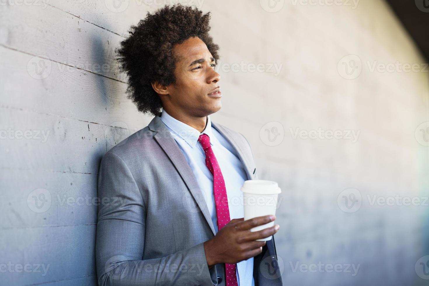 schwarzer Geschäftsmann macht eine Kaffeepause mit einem Glas zum Mitnehmen foto