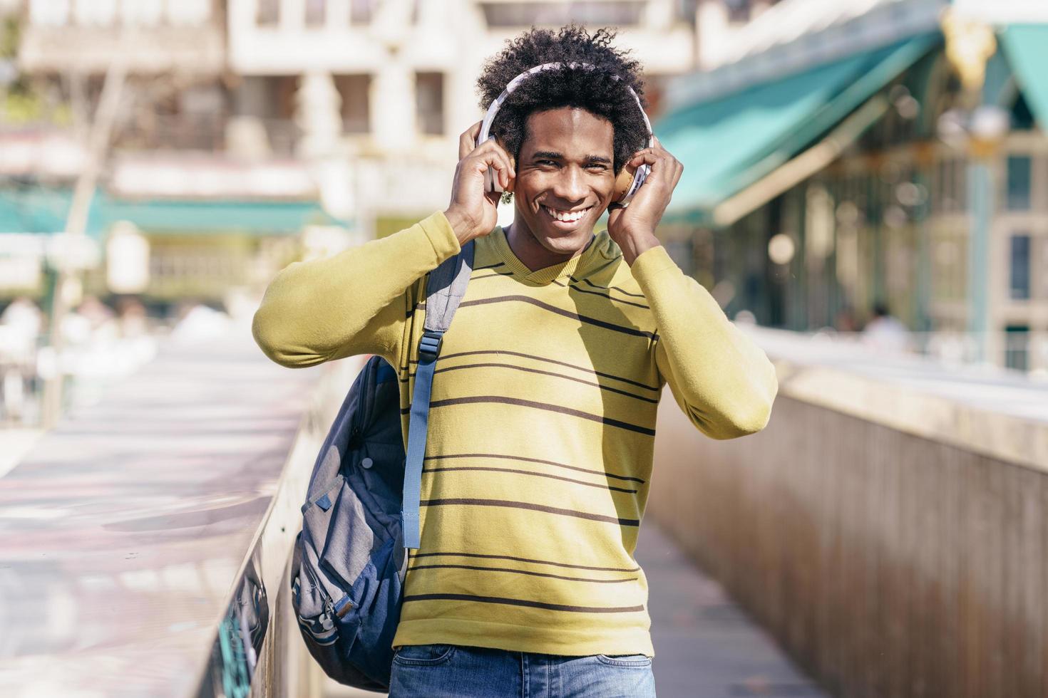 schwarzer Mann hört Musik mit kabellosen Kopfhörern Sightseeing foto