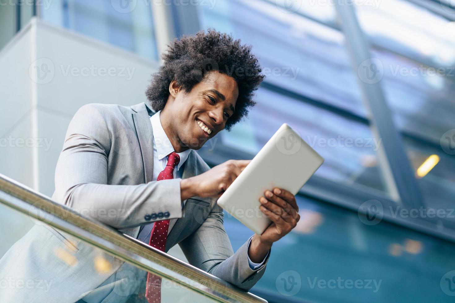 schwarzer Geschäftsmann mit einem digitalen Tablet foto