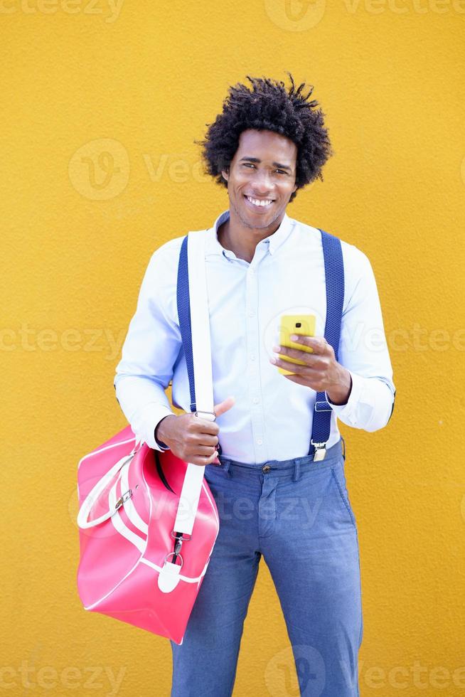 schwarzer Mann mit Afro-Frisur, der eine Sporttasche trägt foto