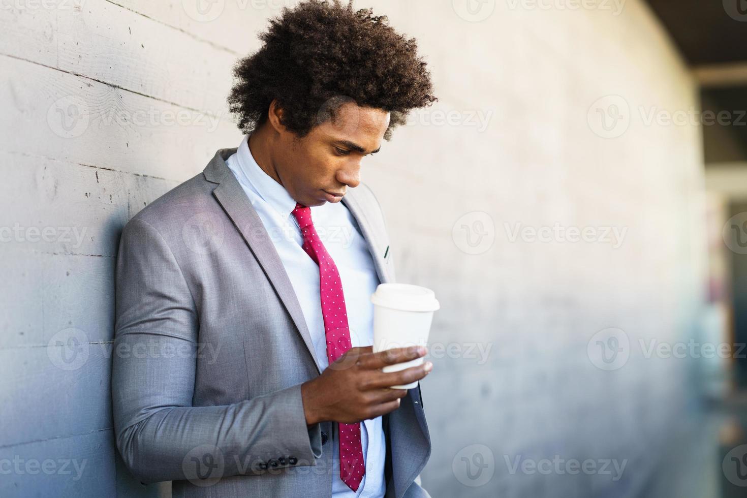 besorgter schwarzer Geschäftsmann macht eine Kaffeepause im Freien foto