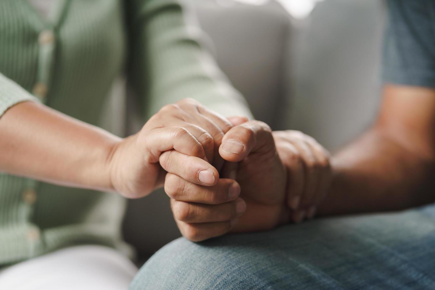 Freund oder Familie, die sitzen und Händchen halten, jubeln dem psychisch depressiven Mann zu foto