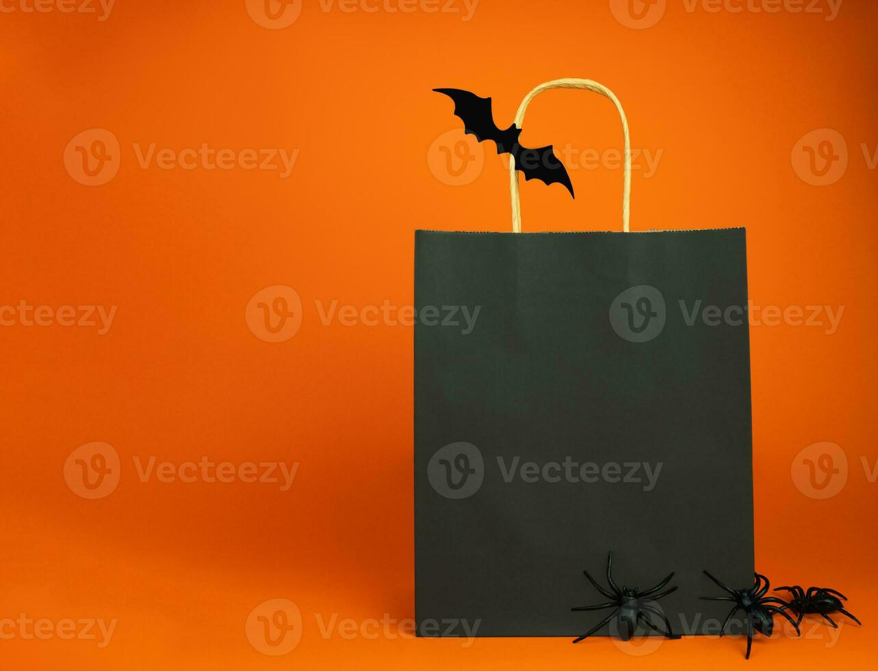 Papier schwarz Tasche und Dekor zum Halloween auf ein Orange Hintergrund. Halloween Einkaufen und Verkauf Konzept. spotten hoch. Kopieren Raum. selektiv Fokus. foto