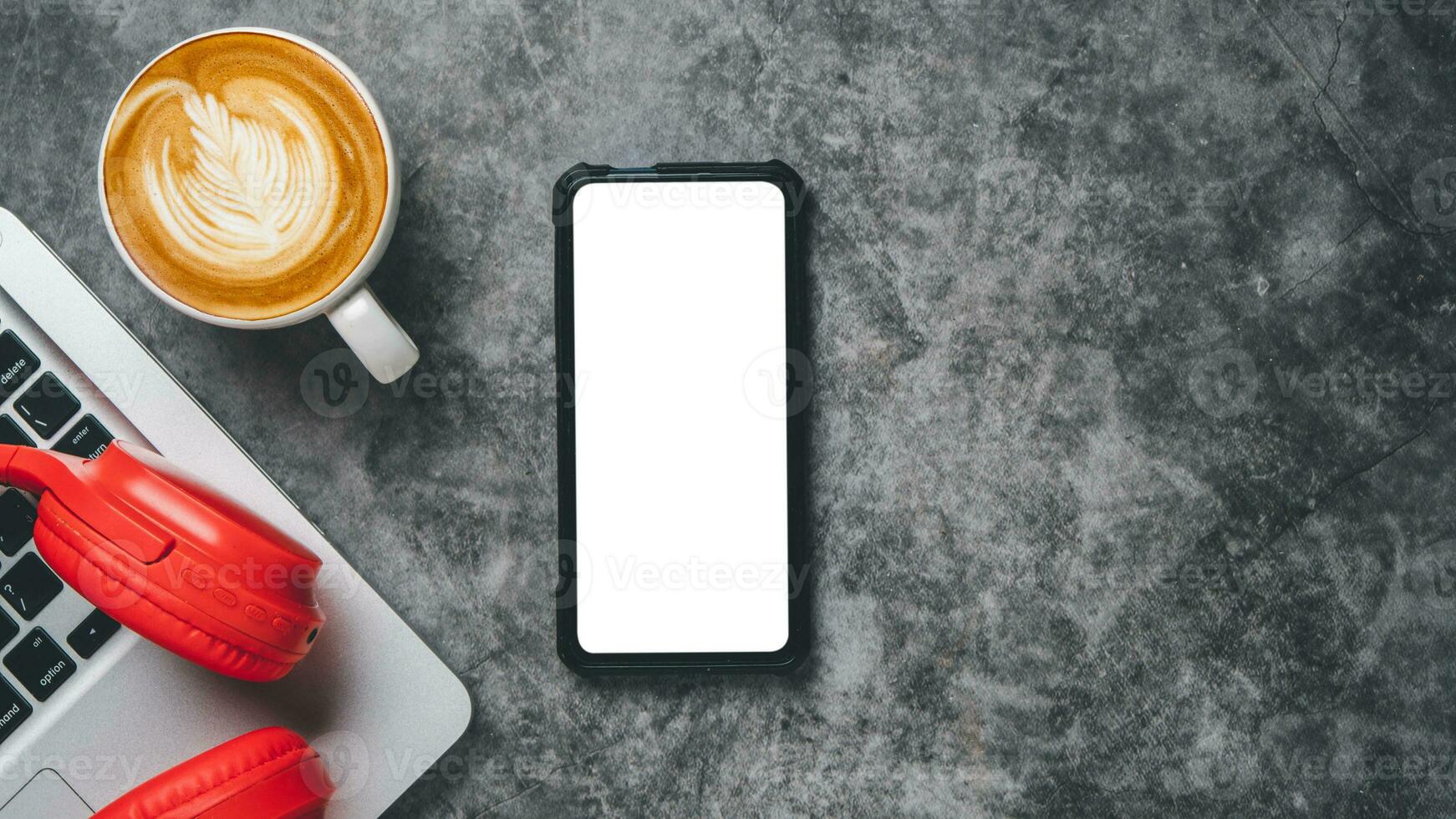 oben Sicht, dunkel Büro Schreibtisch mit Laptop Computer, leer Bildschirm Clever Telefon, Tasse von Kaffee und Kopfhörer, Kopieren Raum, spotten hoch.. foto