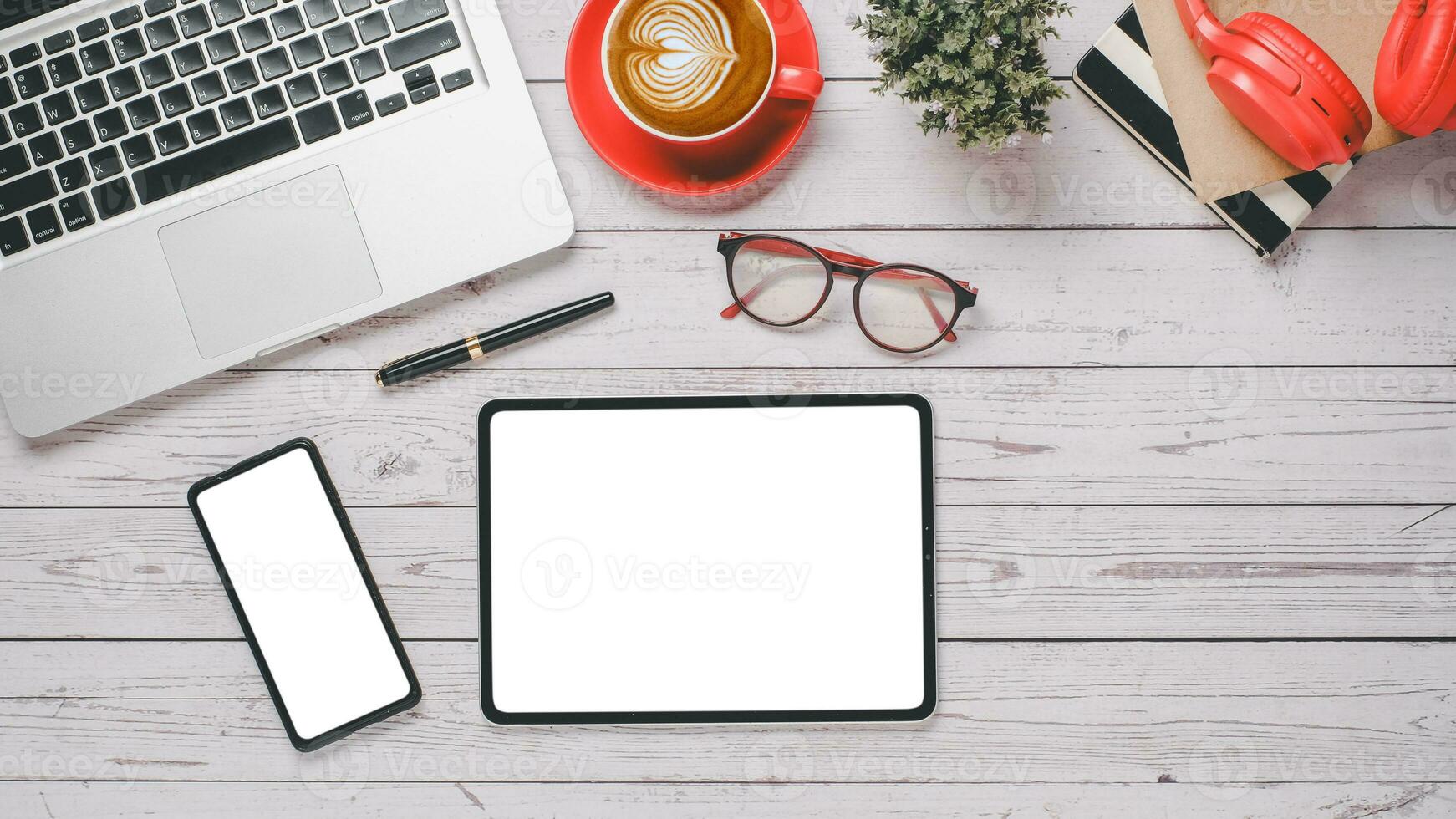 Weiß hölzern Schreibtisch Arbeitsplatz mit leer Bildschirm Tablette und Smartphone, Stift, Laptop, Brille, Kopfhörer, Notizbuch und Tasse von Kaffee, oben Aussicht eben legen mit Kopieren Raum. foto