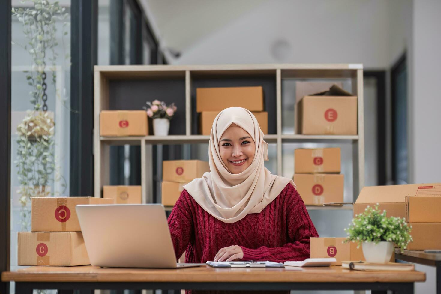 Muslim Frau online Geschäft klein Geschäft Inhaber Verkäufer Unternehmer Verpackung Paket Post Versand Box vorbereiten Lieferung Paket auf Tisch. E-Commerce fallen Versand Sendung Bedienung Konzept. foto