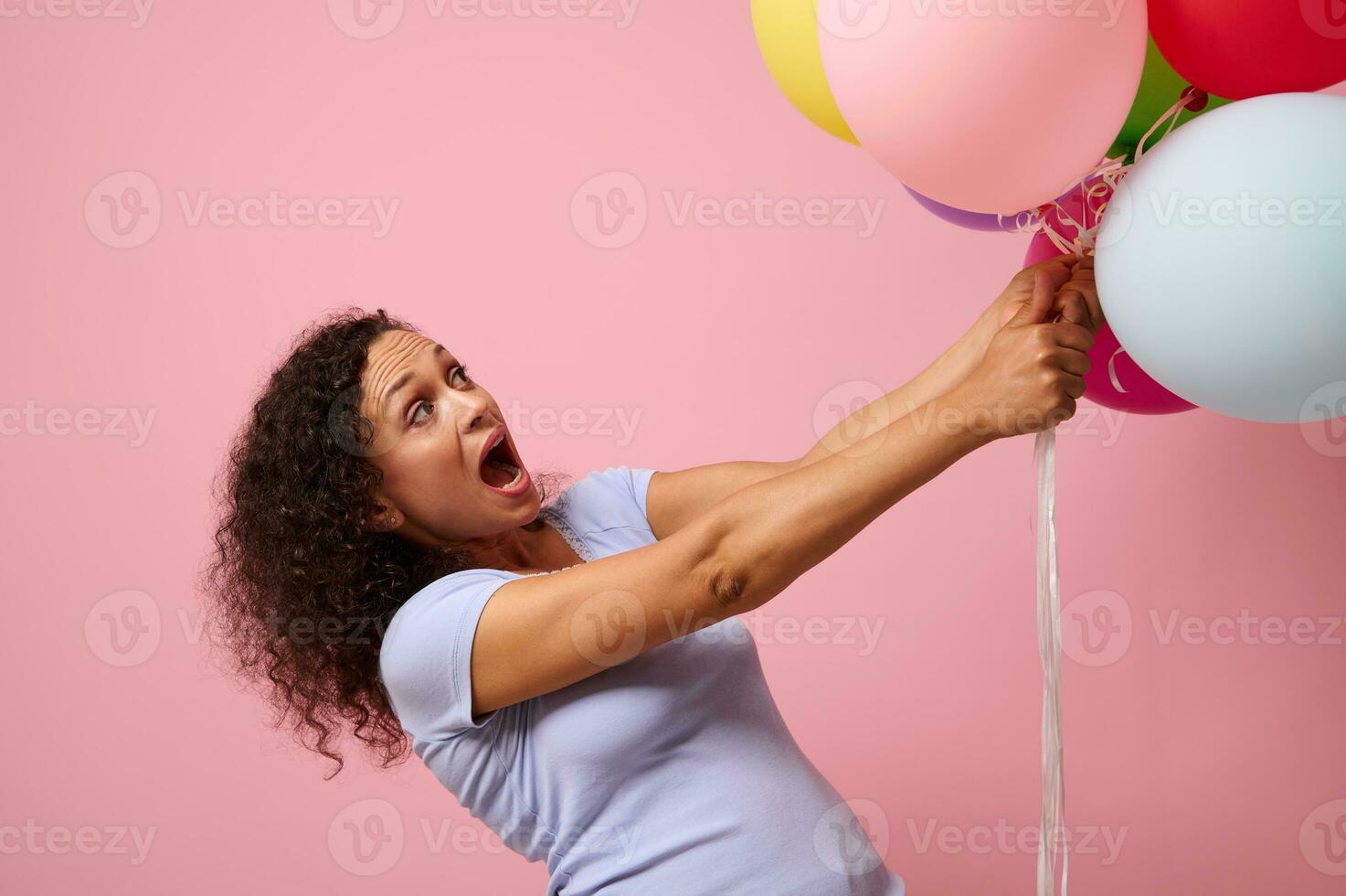 Studio Schuss zum Werbung von ein überrascht Frau erreichen zum bunt Luft Luftballons, Stehen gegen Rosa Hintergrund mit Kopieren Raum. das Konzept von Feier, Feiertage, Jahrestag und Geschenke. foto