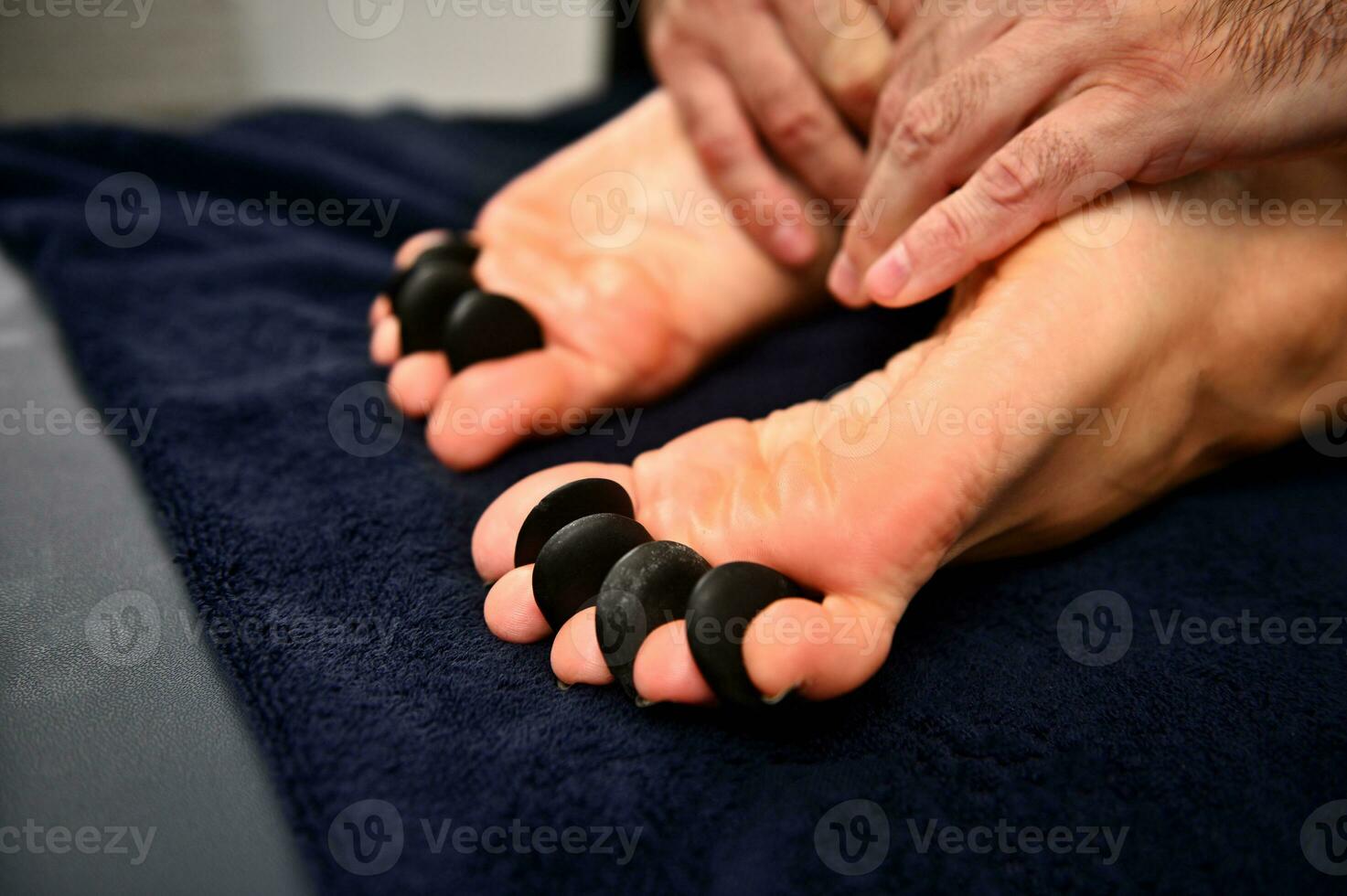 Nahansicht von Frau Füße Empfang heiß Stein Massage im ayurvedisch Wellness Kurort foto