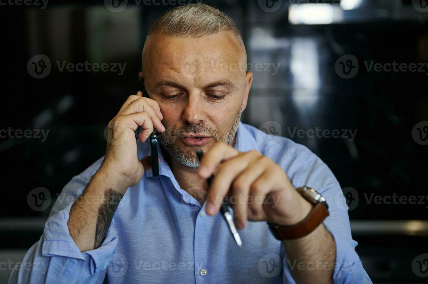 zuversichtlich Porträt von gut aussehend Mitte alt Mann reden auf Handy, Mobiltelefon Telefon, halten ein Stift im seine Hand foto