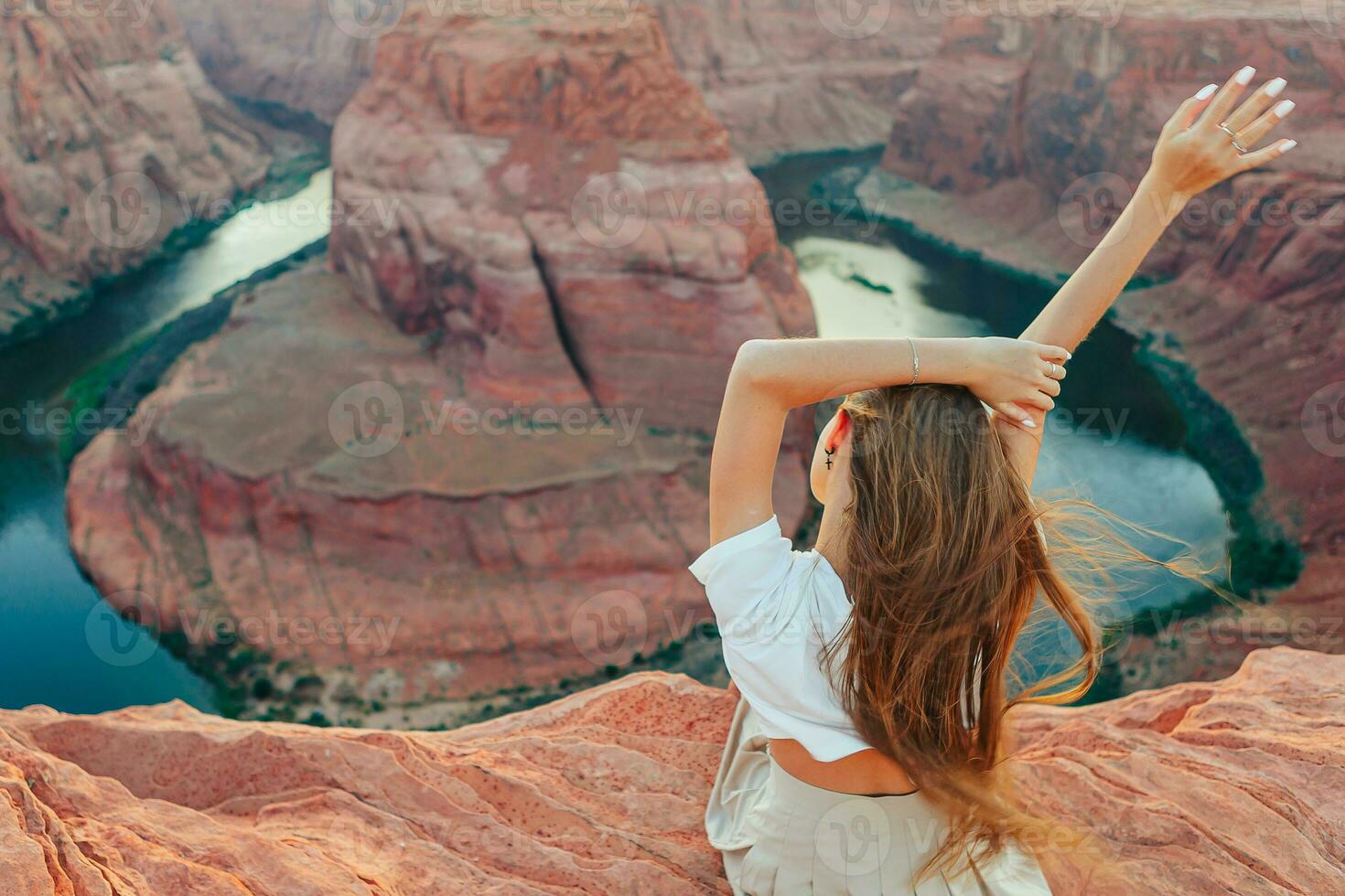 glücklich Mädchen auf das Kante von das Cliff beim Hufeisen Band Schlucht im Buchseite, Arizona. Abenteuer und Tourismus Konzept. schön Natur im USA foto