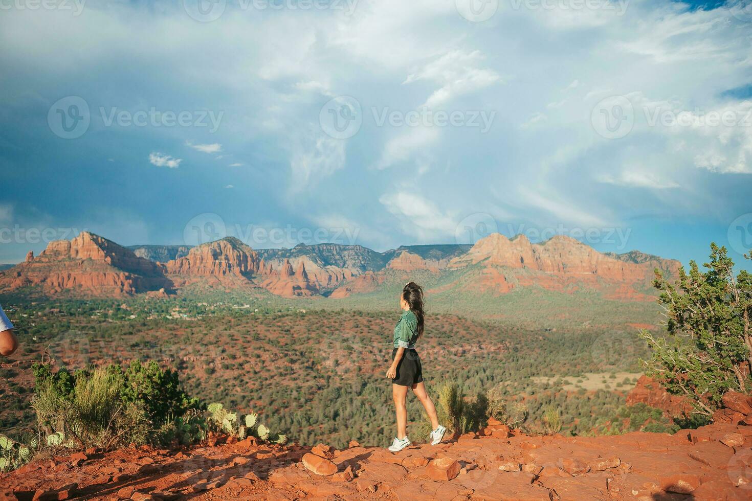 jung Wanderer Frau auf das Kante von ein Cliff beim Kathedrale Felsen im Sedona, Arizona. Aussicht von szenisch Kathedrale Felsen im sedona mit Blau Himmel im Arizona foto