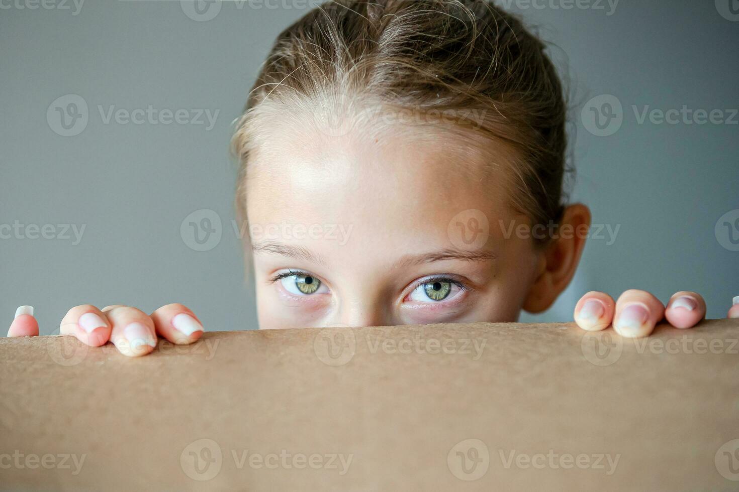 glückliches Mädchen mit schönen grünen Augen im neuen Haus mit Karton foto