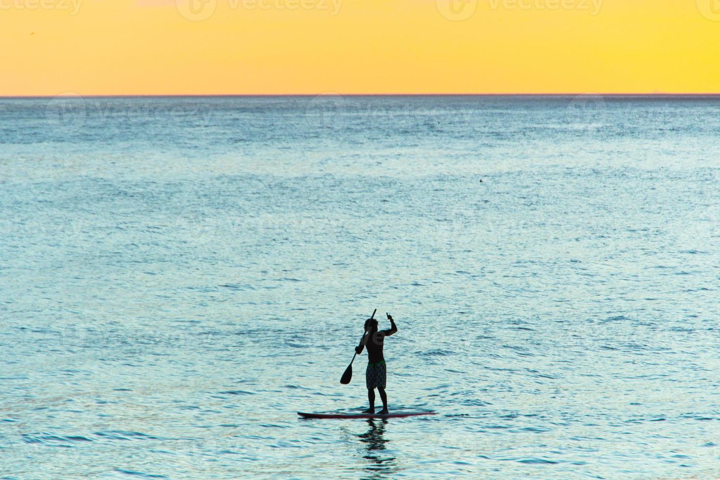 Silhouette des Mannes mit seinem Stand Up Paddle am Strand von Ipanema, in Rio de Janeiro, Brasilien foto