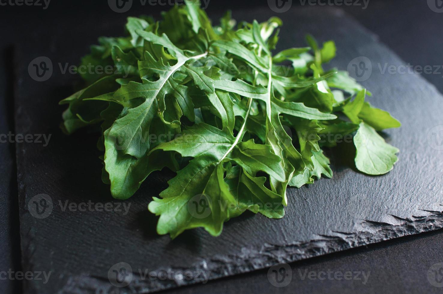 frischer Rucola auf einem schwarzen Brett foto