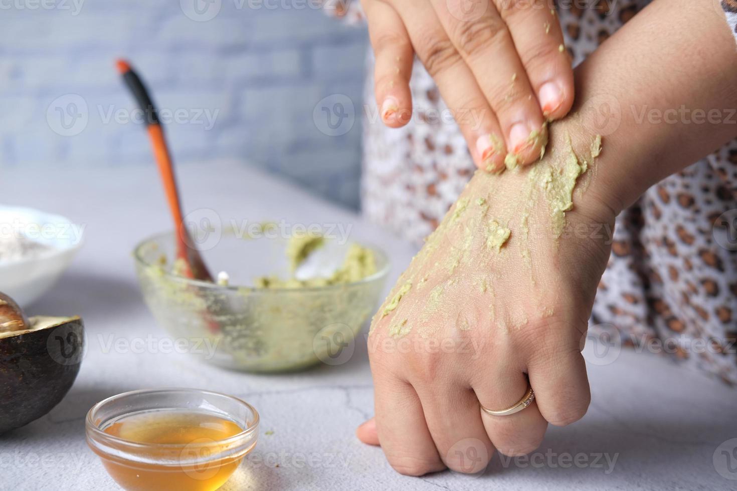 Frauen, die hausgemachte natürliche Avocado-Kosmetikcreme auf die Haut auftragen, foto