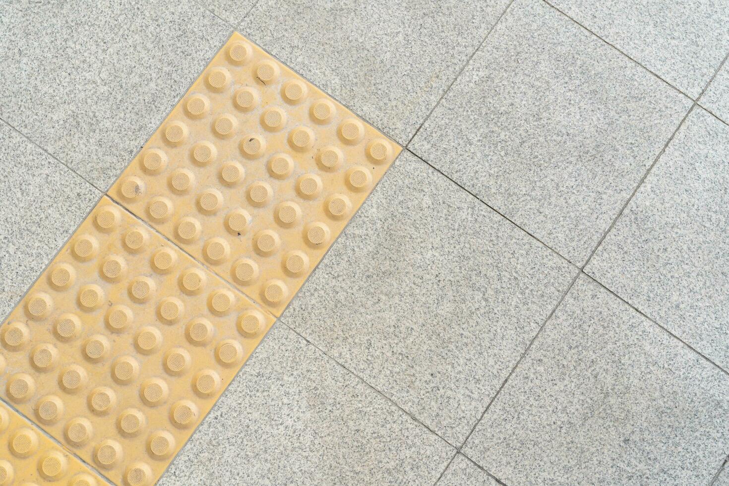 schließen oben Gelb Farbe blind Fußboden Fliesen auf Öffentlichkeit Gehweg. Gelb blind Fußboden Spur auf das Straße foto