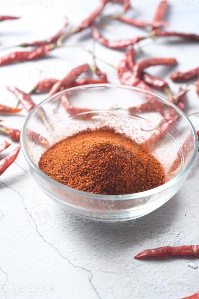 Chilipulver und getrocknete Paprika auf Tischhintergrund. foto