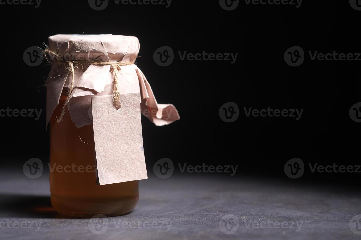 frischer Honig in einem Glas mit leerem Papieretikett foto