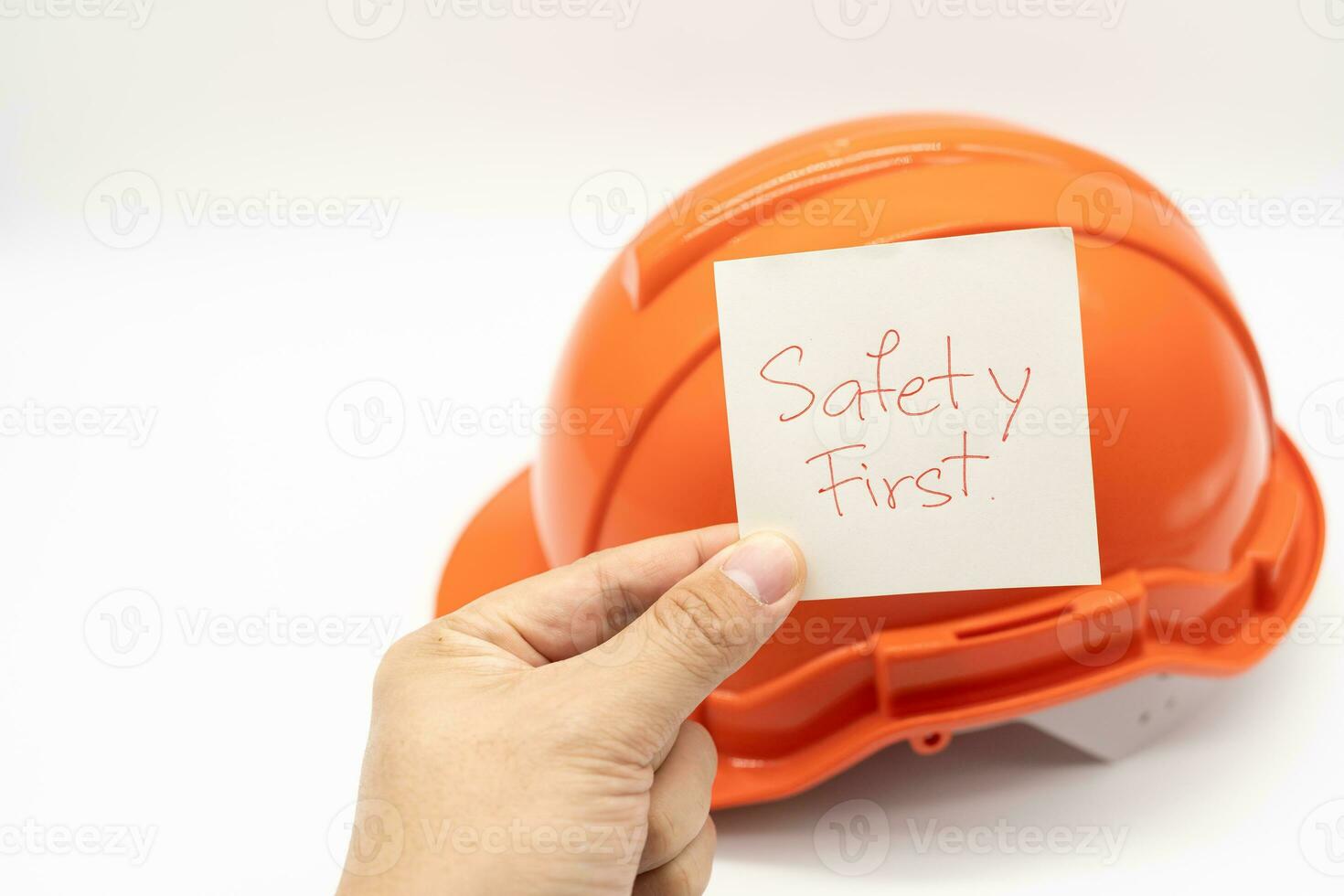 Hände zeigen Sicherheit zuerst Text mit Orange Sicherheit Hut auf das Hintergrund. isoliert Hintergrund. foto