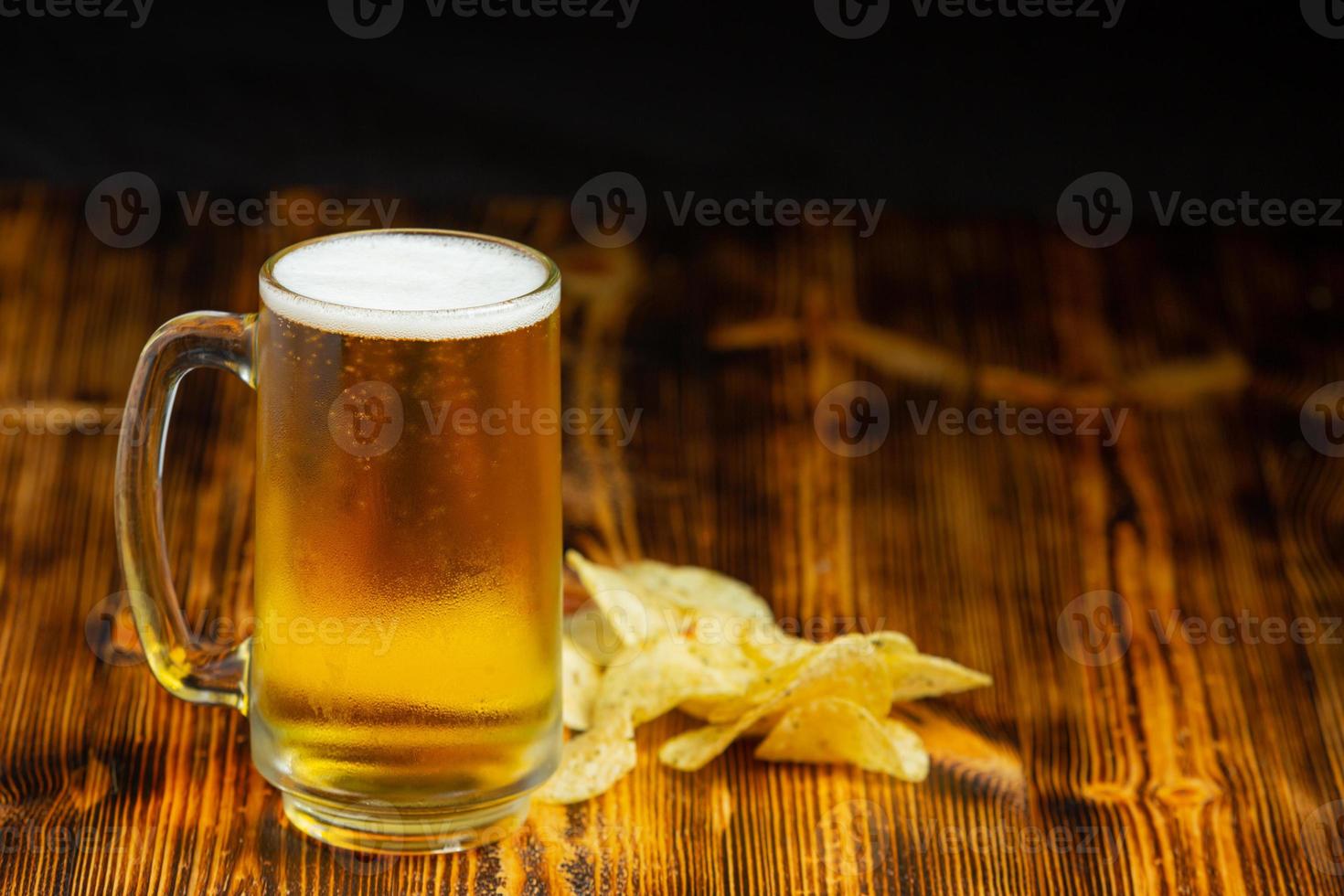 Auf dem Holzboden steht ein Glas Bier. foto