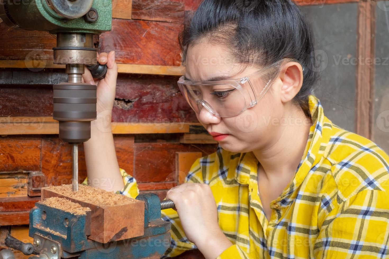 Frauen stehen ist Handwerksbohrer Holz foto