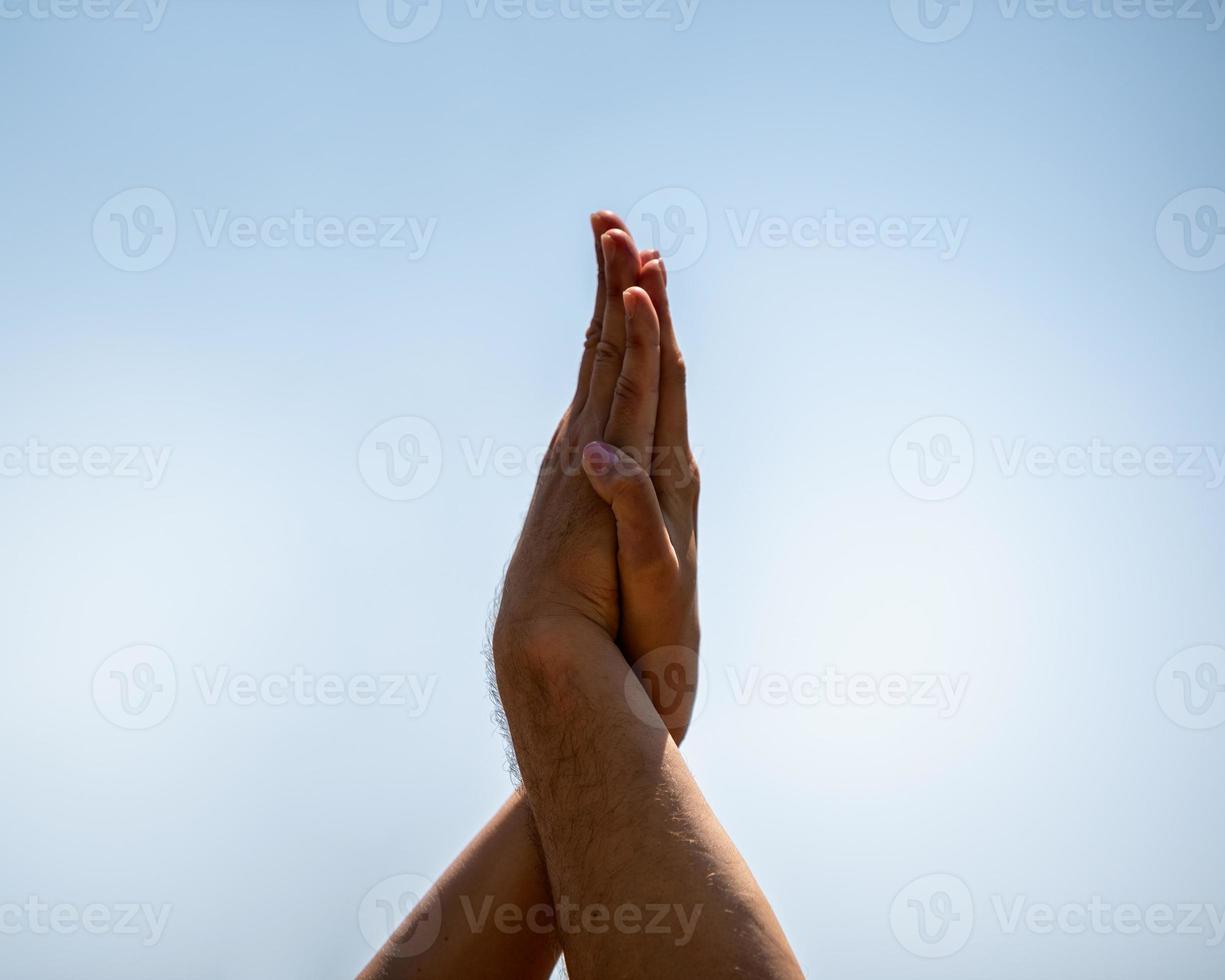 Hände von Leuten, die Yoga am Strand machen foto