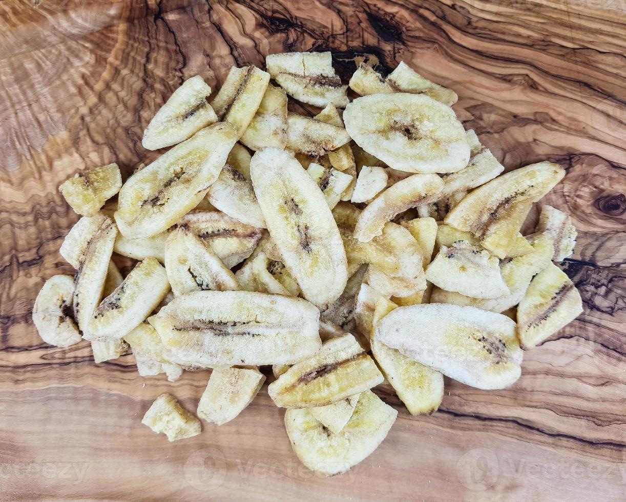 getrocknete Bananenchips auf Olivenholz foto