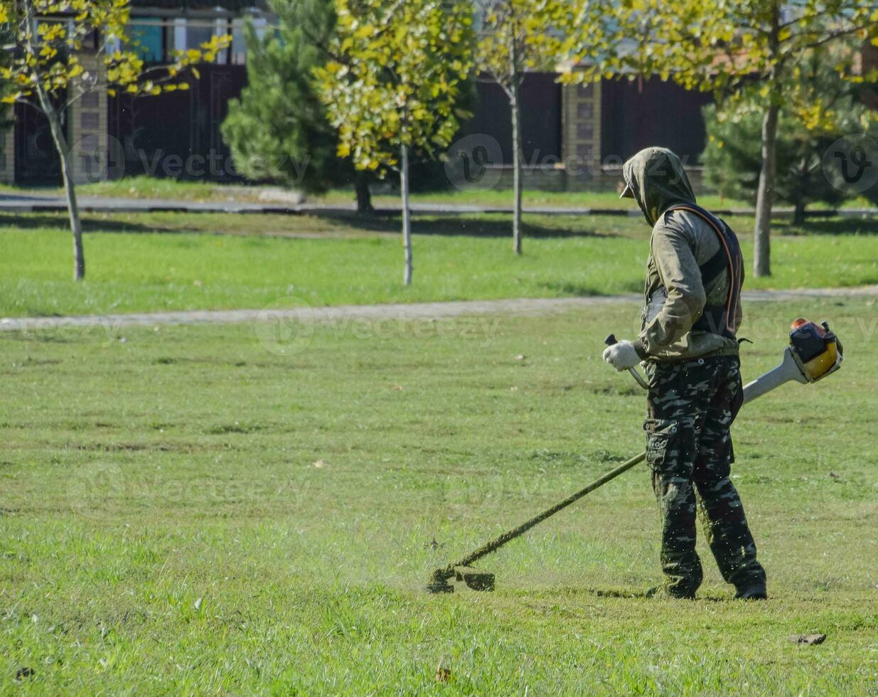 Arbeiter Mähen das Rasen. Mähen Gras Trimmer foto